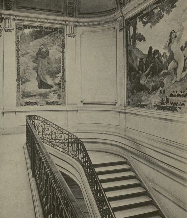 image en noir et blanc montrant un escalier ainsi que deux fresques peintes aux murs.