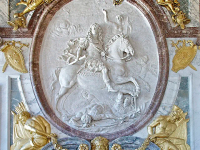 Relief en stuc blanc de Louis XIV à cheval, vêtu en empereur romain, couronné par une victoire et foulant des ennemis au sol.