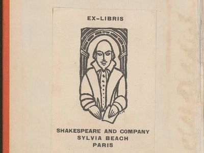 portrait dessiné schématiquement d’un homme en buste de face au centre d’une arche. Il est chauve avec une moustache. Il est vêtu à la mode du XVIe siècle. Il tient une plume dans la main droite et une feuille dans la main gauche. L’homme fait référence au dramaturge anglais William Shakespeare. Son portrait est encadré par les mots « Ex-Libris, Shakespeare and Company, Sylvia Beach, Paris. »