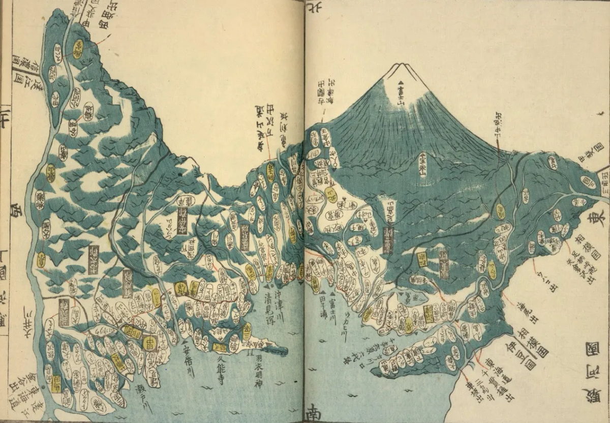 Double page de l'atlas figurant le mont Fuji en vue à vol d'oiseau : cône enneigé dominant la composition, flancs bleu-vert striés de ravines, provinces et localités en cartouches ovales jaunes et blancs sur fond bleu ondulé.