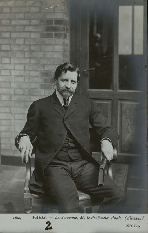 Photographie en noir et blanc de Charles Andler, professeur à la Sorbonne, datant du début du XXe siècle. Assis dans un fauteuil devant un mur de briques, il porte un costume sombre et arbore une barbe fournie. Sa posture est décontractée, les bras reposant sur les accoudoirs du fauteuil. Au bas de l'image figure la légende : 'PARIS. - La Sorbonne, M. le Professeur Andler (Allemand)'. La photographie porte le numéro 1699 et est créditée 'ND Phot'.