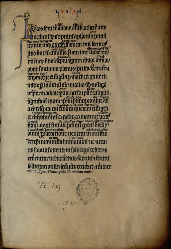 Page droite d'un manuscrit médiéval à une seule colonne avec très large marge droite vide. Titre courant rubriqué rouge et bleu "LUCAS" en marge supérieure. Cachet du Collège Louis-le-Grand du 18e siècle en marge inférieure, avec large cote à l'encre brune ancienne à sa gauche. Certains mots sont écrits entre les lignes sur un autre en plus petit. Une lettrine L ouvre la page, sans fond, et dont deux hampes débordent de façon parallèle en marge gauche.