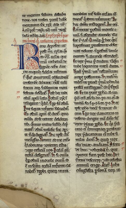 Page gauche d'un manuscrit médiéval à deux colonnes aux lignes réglées. Lettrine bleue R à rinceaux rouges au premier tiers de la colonne gauche. Large tache brune à l'angle gauche inférieur bordée de ronds de taches, avec plis affectant toute la parte basse de la page.